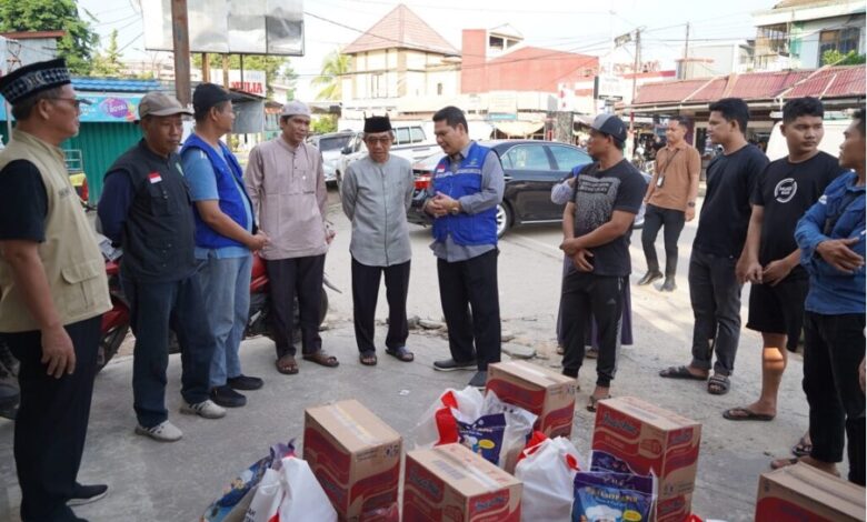 Bupati Kutim Ardiansyah Sulaiman, bersama Kadinsos Kutim, Ernata Hadi Sutijo dan perwakilan Baznas Kutim menyerahkan bantuan kepada warga